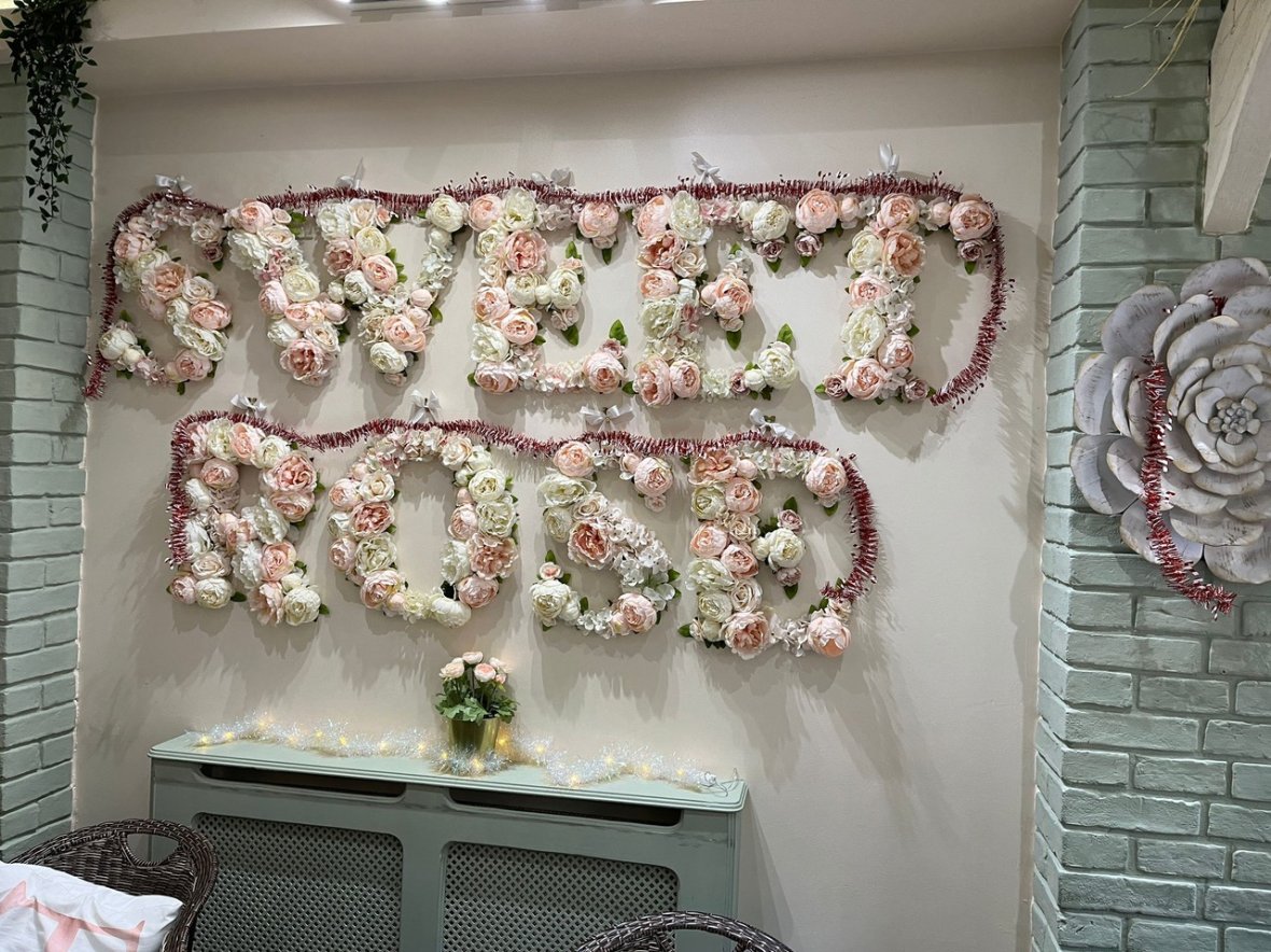 Sweet Rose Cakery sign made of pink and white flowers
