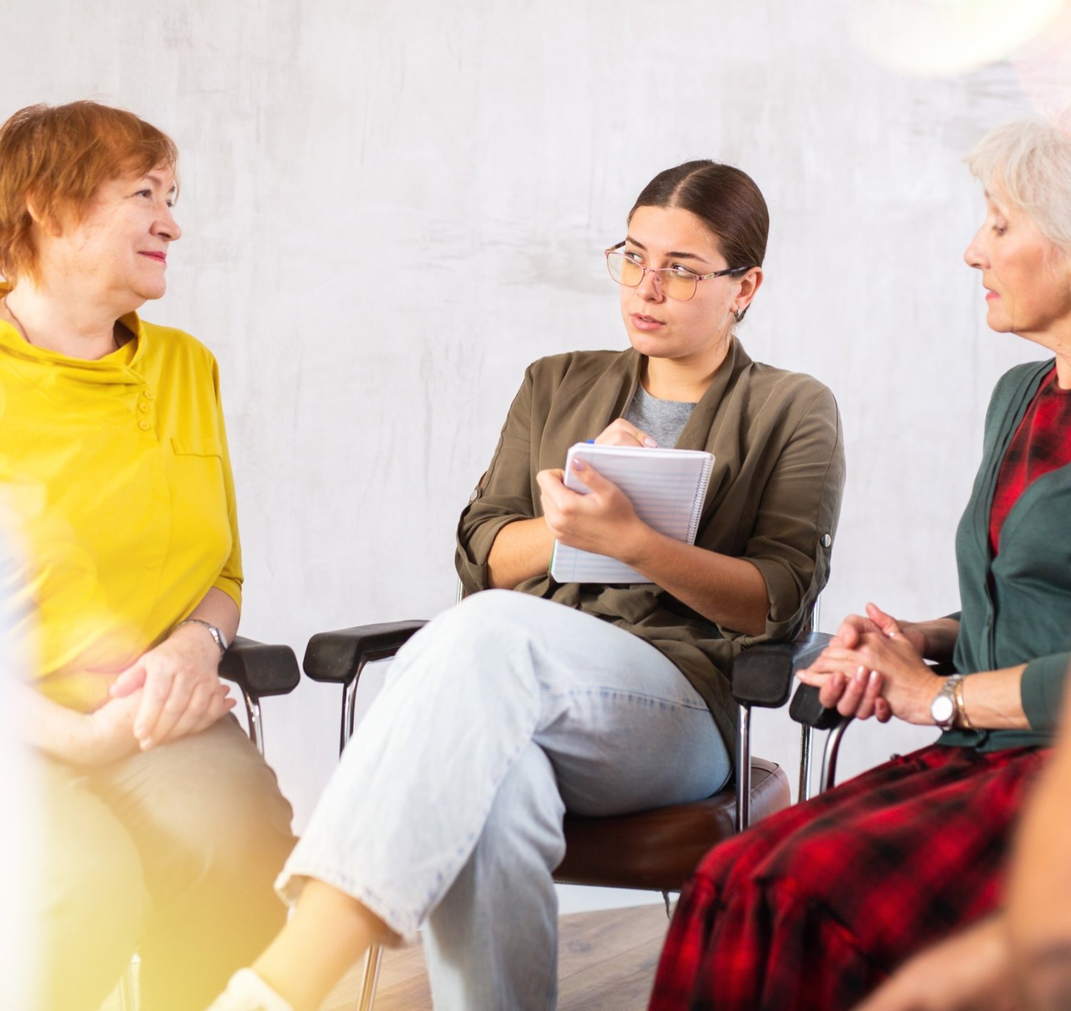 Two women sitting and talking, one taking notes in a notepad